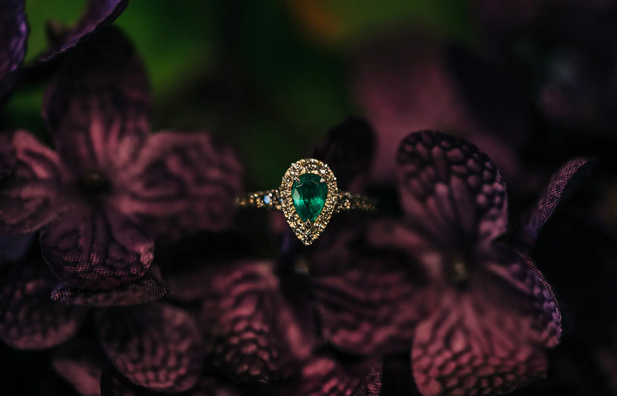 Pear shaped emerald gold halo ring with surrounded with deep purple flowers