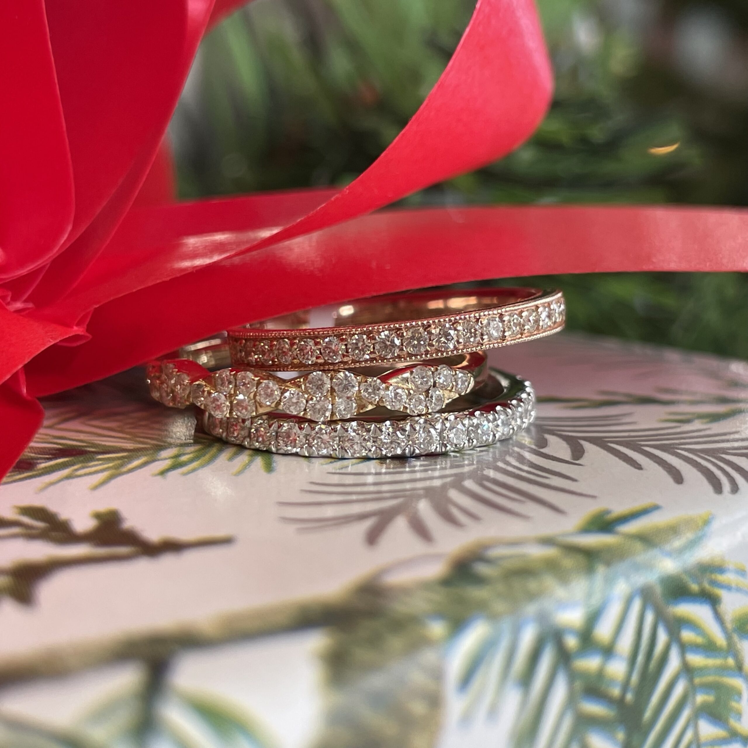Stack of mixed metal diamond rings a top a present